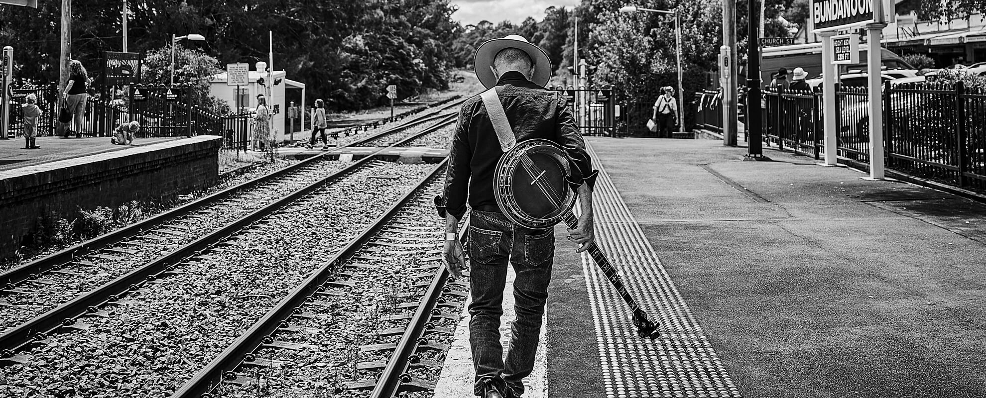 Peter Campbell walking away with banjo over shoulder